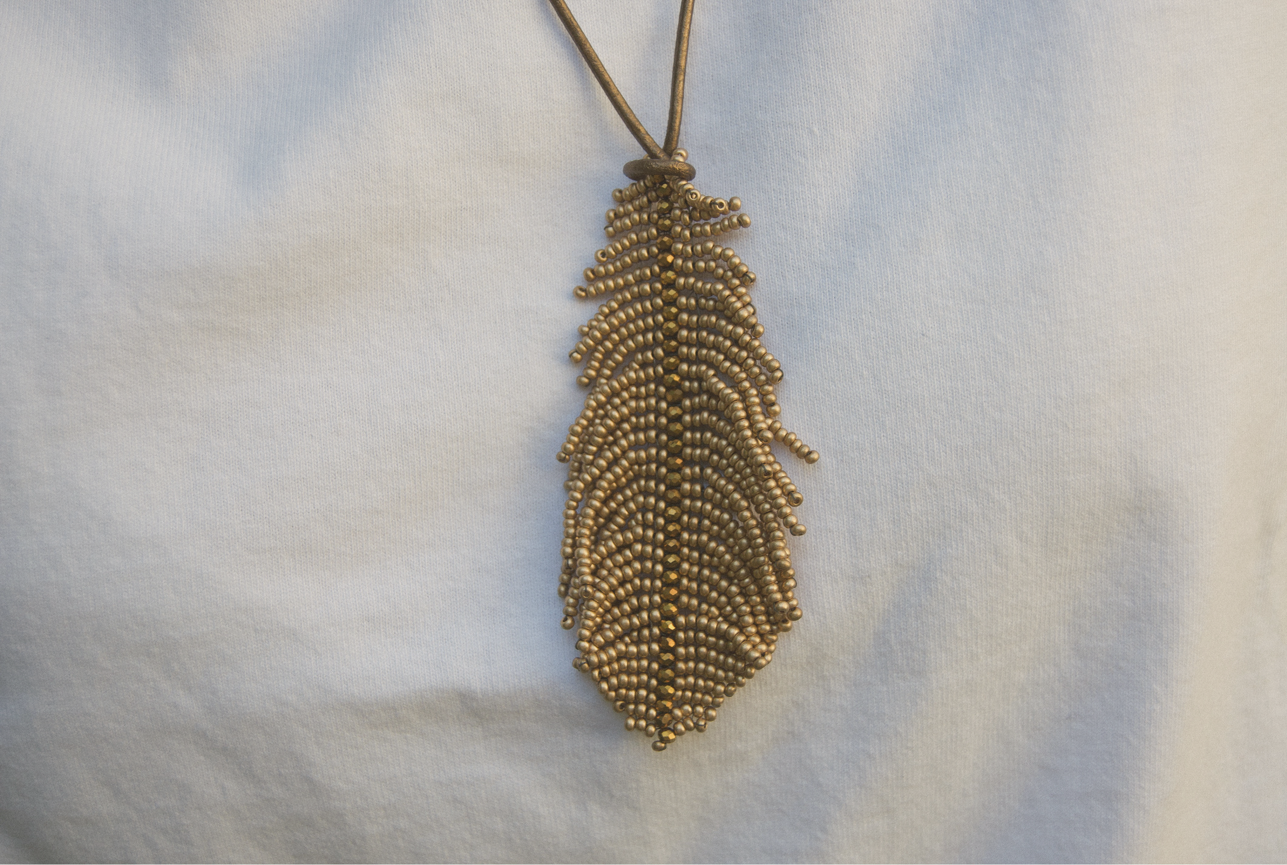 Colgante artesanal en forma de pluma